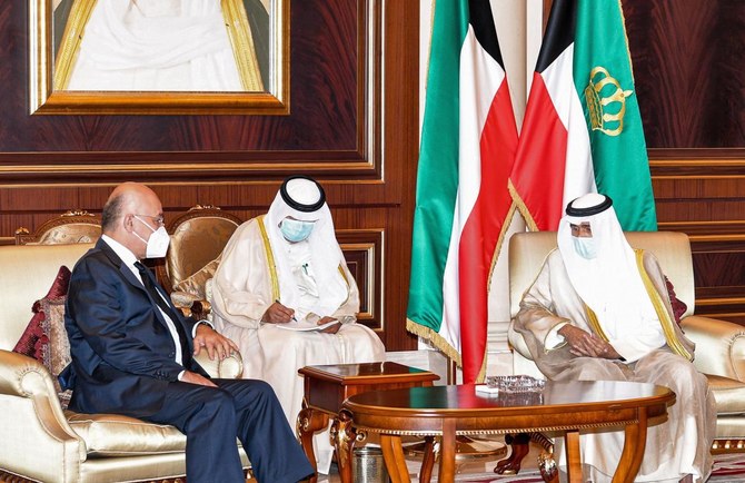 2020年10月1日にクウェート王宮広報室が配信した写真に、イラクのバルハム・サレフ大統領（左）がクウェート国際空港のエミーリーターミナルで、クウェートのナワフ・アル-アーメド・アル-サバハ新首長（右）と対面し、故人への弔意を述べている様子が写る。 （AFP）