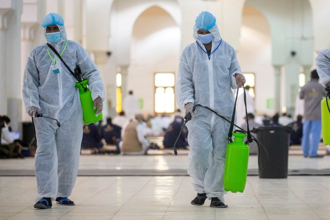イスラム教徒の巡礼者が聖地マッカの外、アラファトのナミラモスク内で祈る中、個人用保護具（PPE）を着用した医療従事者が床を消毒する。 （ファイル/ロイター）
