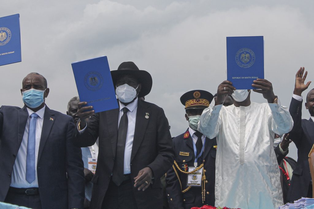 スーダン最高評議会のアブデル・ファタハ・アル・ブルハン議長（左）、南スーダンのサルバ・キール大統領（中央）、チャド共和国のイドリス・デビ大統領（右）が、2020年10月3日にジュバで署名された南スーダン和平協定の写しを掲げている。（AFP）