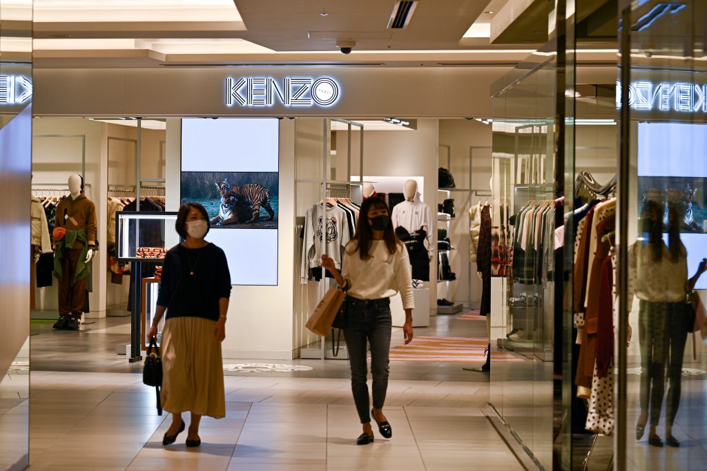 2020年10月5日、日本のファッションデザイナー高田賢三氏がパリで81歳で亡くなった翌日、東京の「KENZO」ファッションストアの外を歩く人々。（AFP）
