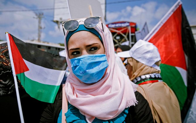 2020年6月6日、イスラエル占領下のヨルダン川西岸地区のカフル・カドゥム（Kfar Qaddum）村で、ユダヤ国家による領土の一部併合計画に反対するデモで国旗を振るパレスチナ人の抗議者。（写真：JAAFAR ASHTIYEH/AFP通信）