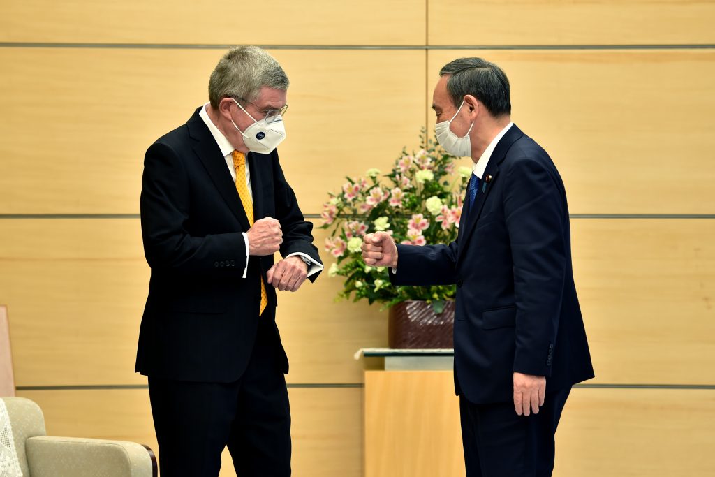 2020年11月16日に東京での会談で挨拶を交わす日本の菅義偉首相 (右) と国際オリンピック委員会 (IOC) のトーマス・バッハ会長 (左) (AFP)