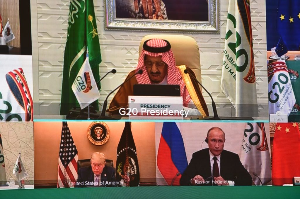 2020年11月21日、サウジアラビアの首都リヤドの国際メディアセンターで新型コロナウイルスの大流行の影響で仮想で開催されたG20サミットの開会の挨拶をする投影スクリーンに映し出されたサウジアラビアのサルマーン・ビン・アブドゥルアズィーズ国王と米国のドナルド・トランプ大統領とロシアのウラジーミル・プーチン大統領（左下と右下）。(AFP)