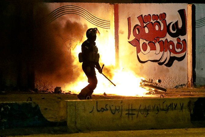 イラクのバスラで治安部隊が反政府抗議者の座り込みテント設置を阻止する中、抗議者のオートバイを燃やす兵士。2020年11月6日金曜。（AP）