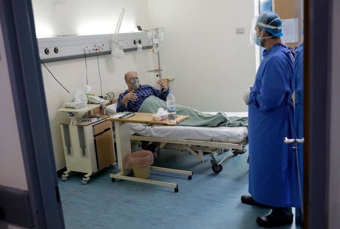 2020年11月13日、レバノンのラフィックハリリ大学病院の集中治療室で、COVID-19の感染患者が医療班の1員と話す。（AFP通信）