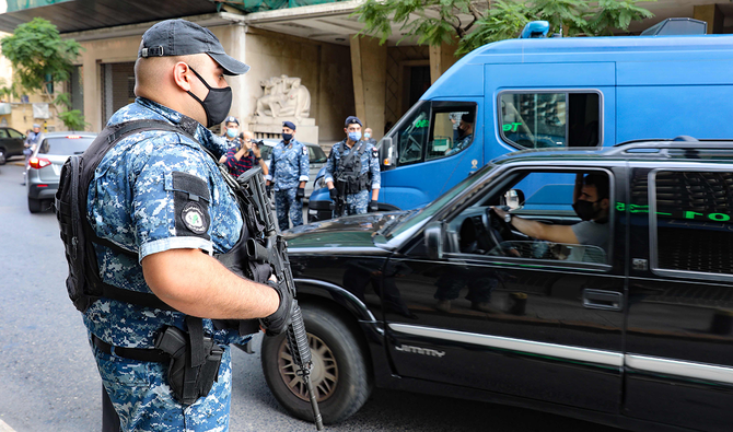レバノンがロックダウンに入った翌日、首都ベイルートのSanayeh地区にある検問所で車をチェックするレバノンの警官。（AFP）
