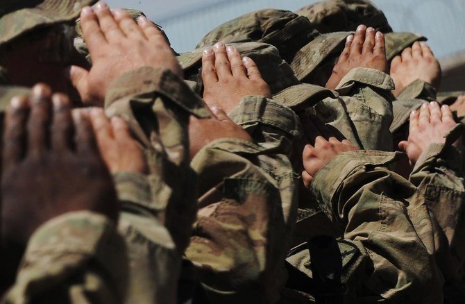 2013年5月20日、ガズニ州の前進作戦基地（FOB）アリアン内で行われた陸軍安全優秀賞の授賞式で、米国歌が演奏される中、第10山岳師団の米軍兵士が敬礼している。（AFP）