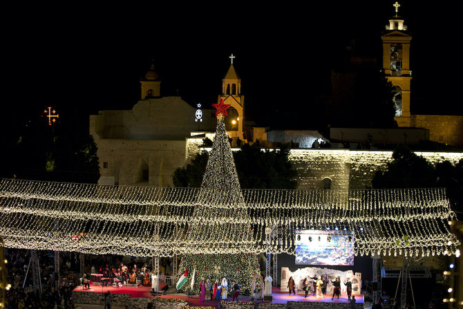 伝統的にキリスト教徒がイエス・キリスト生誕の地と信じるヨルダン川西岸の都市ベツレヘムにある聖誕教会の外で、クリスマスツリーの点灯を祝うパレスチナのキリスト教徒。(File/AP)