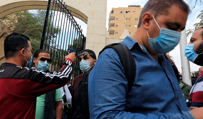 カイロでモスクに入る男性の体温をチェックする警備員。月曜撮影。（ロイター）
