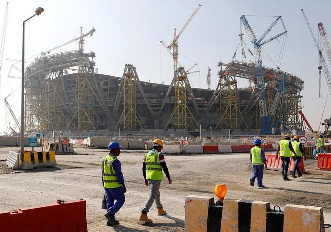 次回2022年のFIFAワールドカップに向けて建設が進められているルサイルのスタジアムの建設現場に向かって歩く労働者たち（2019年12月20日、カタール・ドーハ）。（ロイター通信）