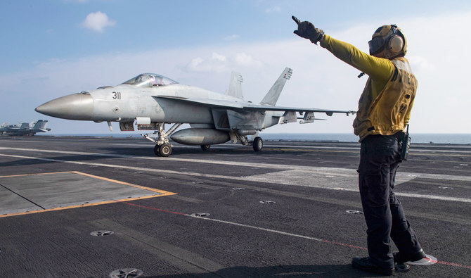 米国海軍公開のこの写真では、カリフォルニア州ラ・プエンタ出身の操舵員マーネル・マグラサン三等兵がF/A-18Eスーパーホーネットに指示を出している。アラビア海、航空母艦USSニミッツの飛行甲板にて、2020年11月27日金曜。（AP）