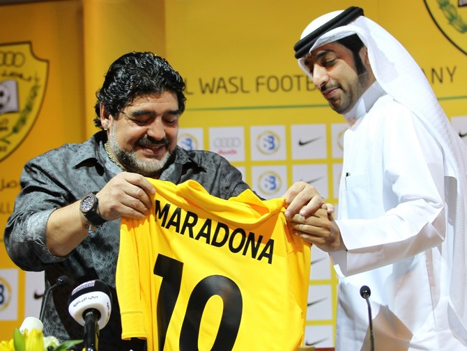 アルゼンチン人のサッカーの伝説ディエゴ・マラドーナ（左）がエミラティ・アル・ワスルサッカー会社会長マルワン・ビン・バヤートとともに新しいシャツを見遣る。2011年9月11日、ドバイで行われた記者会見にて。AFP フォト/カリム・サヒブ　カリム・サヒブ/AFP(AFP/ファイル)