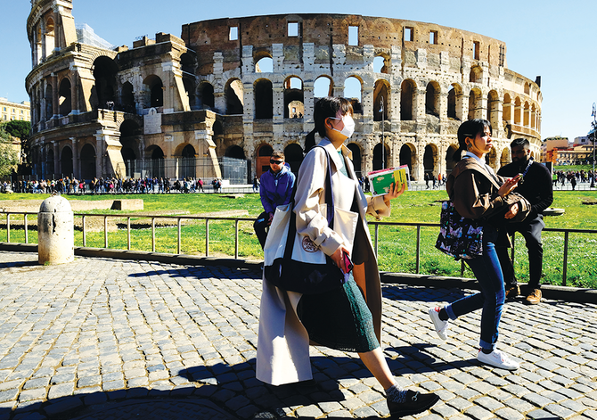 ローマのコロッセオの外で、防護マスクを着用する観光客。(AFP)