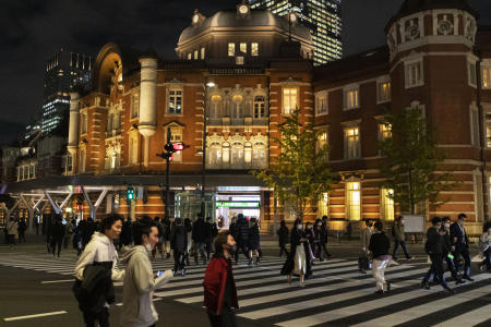 2020年11月12日(木)、コロナウイルスの広がりを抑えるべくフェイスマスクを着用した人が東京駅近くの交通交差点を歩きます。(AP)