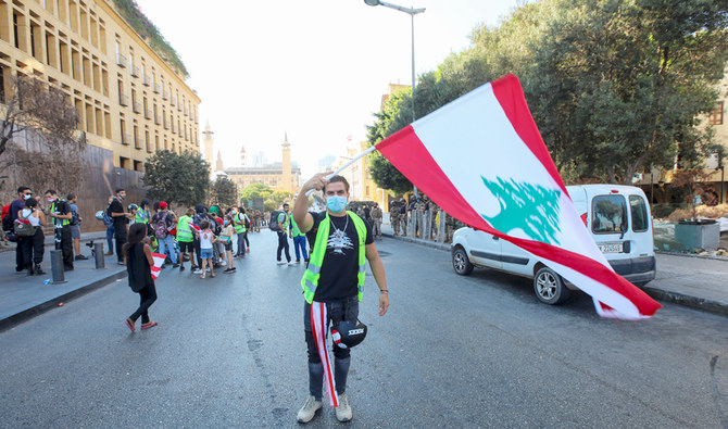 レバノンのベイルートでこのほど行われた抗議デモで、国旗を振るデモ参加者。（AFP）