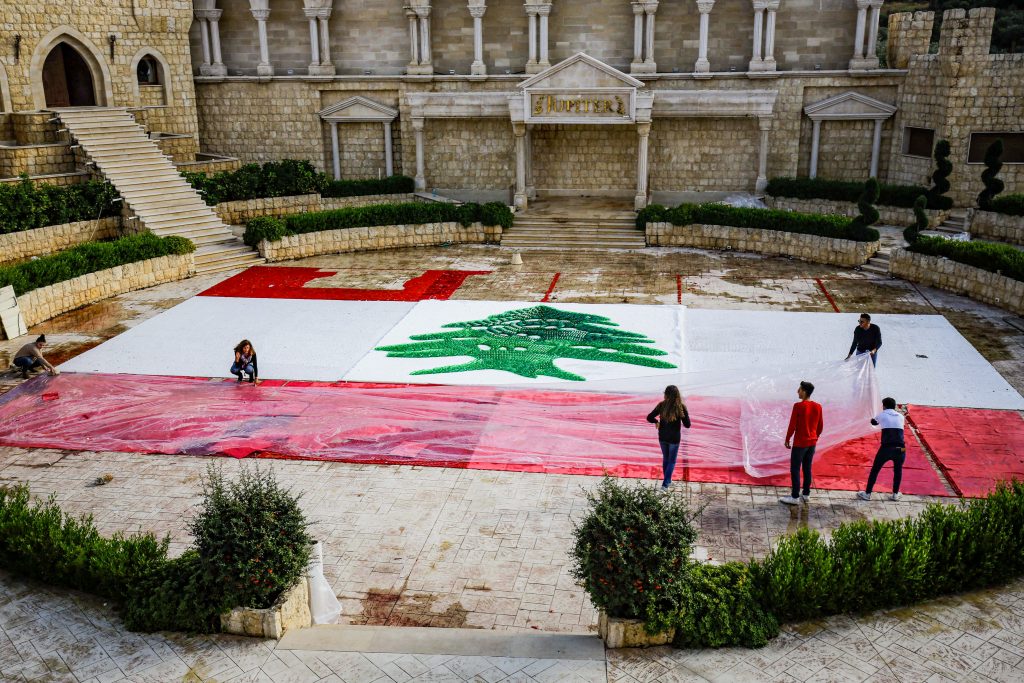 2020年11月21日に撮影されたこの写真には、同国の77回目の独立記念日を1日後に控えたレバノン北部の町ベナシャイで、環境保護活動家らがペットボトルやキャップ、空の弾丸カートリッジを使って作成し、結婚式場にも使用される屋外レストランに設置した、300平方メートルのレバノン国旗の一部完成品が写されている。（AFP）