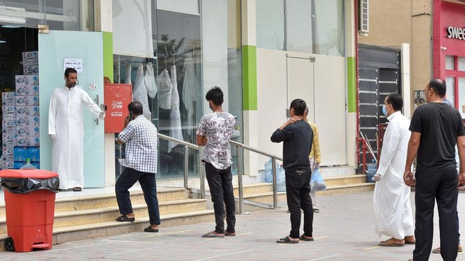 新型コロナウイルスによる感染のリスクを減らすためにリヤドのスーパーマーケットの外で社会的距離を取る顧客。（AFP）