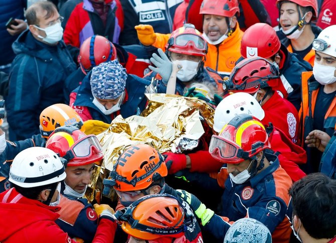 2020年11月2日、エーゲ海の港町イズミルで、地震で倒壊した建物から運び出される際に、救助隊員の親指を握るエリフ・ペリンチェクさん(3歳)。(AFP/イスタンブール消防局)