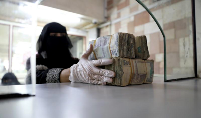 従業員が、サナアのイエメン中央銀行でイエメンリアルの札束を受け取っている。(Reuters/File)