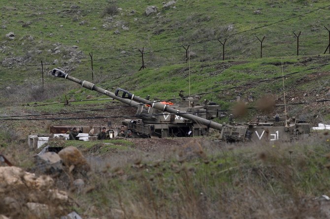 シリアとの国境にあるゴラン高原で、自走榴弾砲の横に集まるイスラエルの兵士たち。（資料/AFP通信）