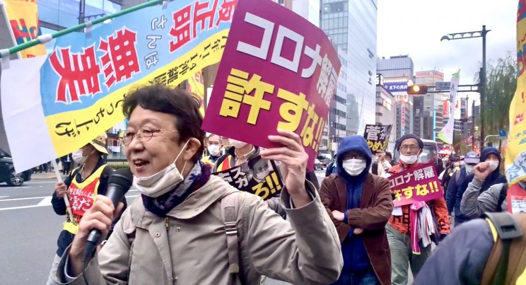 菅義偉首相の辞任を求める小さな横断幕を掲げるデモ参加者たちもいた