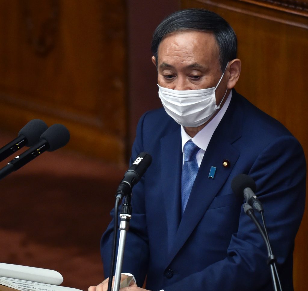 日本の菅義偉首相はマスクを着け、2020年10月26日召集の臨時国会の衆議院本会議場（東京）で初の所信表明演説を行った。（AFP）