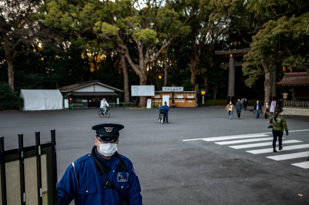 2020年12月31日、東京の明治神宮で、例年より早く門を閉める警備員。（写真提供：Philip FONG / AFP）