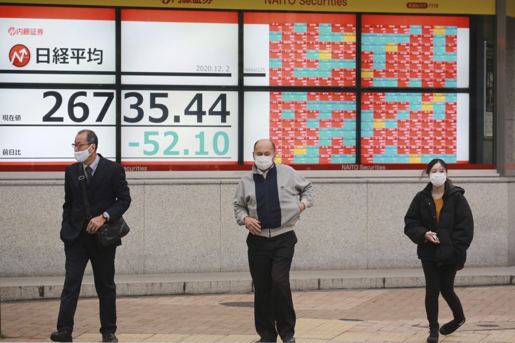東京の証券会社の株価掲示板を通り過ぎる人たち(2020年12月2日)(写真/AP)