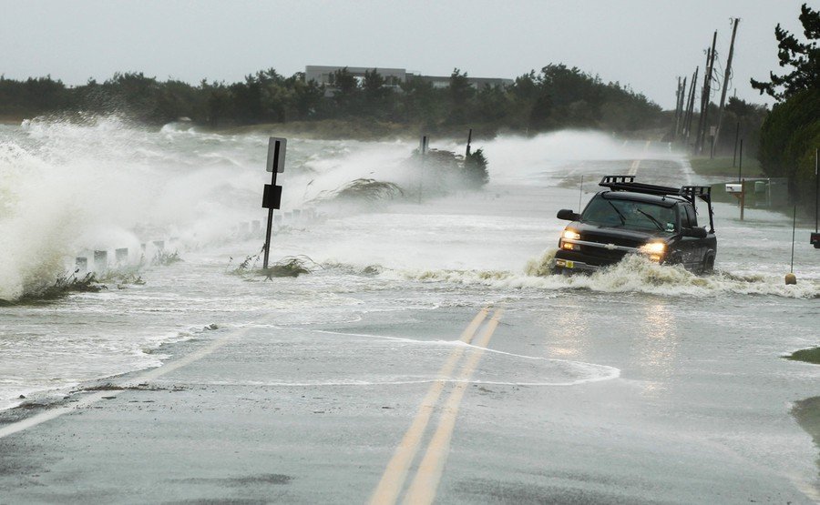 2012年10月29日、ニューヨーク州サウサンプトンで、ハリケーン「サンディ」で道路に押し寄せられた水の中を1台のトラックが通る。（ロイター）