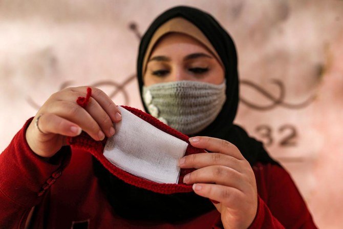 ガザ市で手作りのかぎ針編みのウールマスク（COVID-19新型コロナウイルスの感染拡大防止対策）を作成する24歳のパレスチナ人、ノウラン・ファラジ氏、2020年12月1日。（AFP通信）