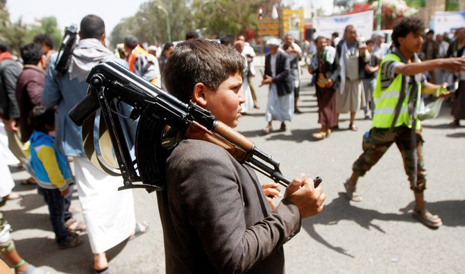 2020年4月2日、イエメンのサヌアでの集会中、フーシ派の支持者と共に武器を携帯する少年が写っている。（ロイター通信）