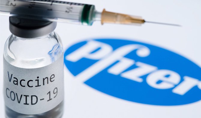 2020年11月23日に撮影されたこの資料写真には、ファイザー社のロゴの横に「COVID-19ワクチン」と書かれた注射器や瓶が写っている。（AFP）