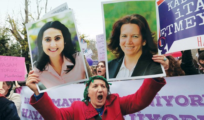 トルコ大統領を侮辱した罪で起訴されて投獄された議員フィゲン・ユクセクダグ（左）とアンカラのセルマ・イルマックの写真を持つ女性。（AP）