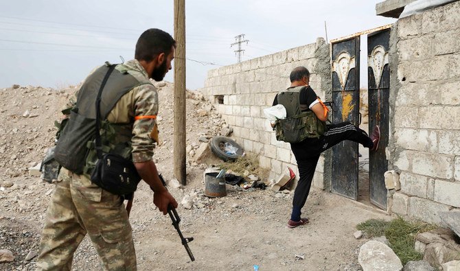 重要拠点となっているシリア国境の町ラース・アル=アインで住宅の玄関をこじ開けるトルコ支援のシリア人兵士。2019年10月19日撮影のファイル写真。(AFP)