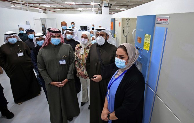 2020年12月23日、クウェート市内にある国際催事場のクウェート・ワクチン接種センターで、シェイフ・バゼル・アル・サバハ・クウェート保健相（右から2番目）が、新型コロナワクチンの入った冷蔵庫の傍らに立っている。（資料/AFP）