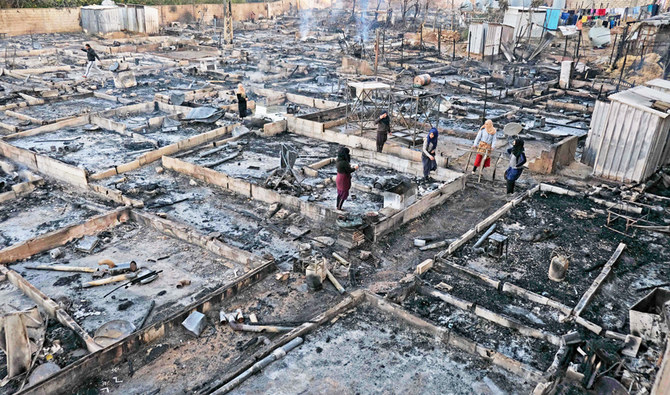 難民キャンプのメンバーと地元レバノン人たちとの間の争いを受けて一夜にして放火されたレバノン北部の町ブハニーンにある難民キャンプの焼け跡で所持品を探すシリア難民たち（2020年12月27日撮影）。（AFP通信）