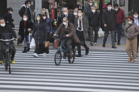 2020年12月15日(火)、東京の路上でコロナウイルスの蔓延から保護するためにフェイスマスクを着用した人々。(AP)
