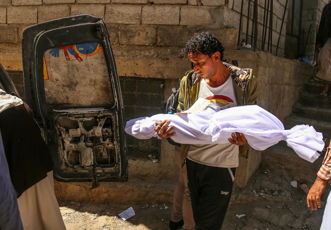 イエメンの男性が、一触即発のイエメン南部の都市タイズへの迫撃砲攻撃で死亡した子供の遺体を運ぶ。（資料/AFP）