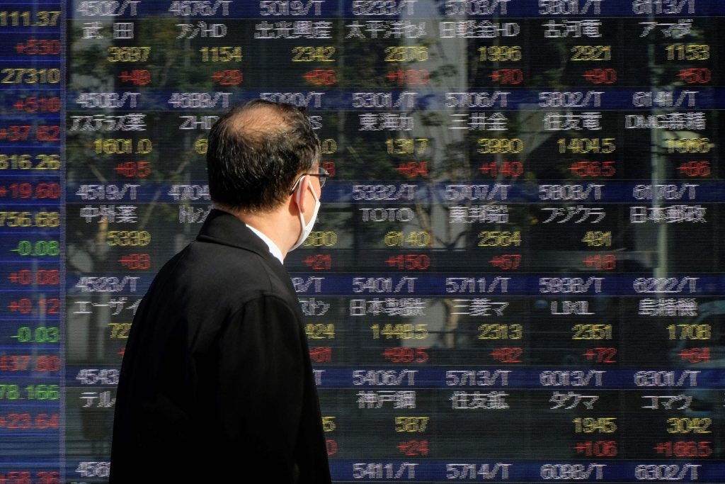 東京証券取引所の株価ボードを眺める歩行者。東京、2021年1月7日。 (File photo/AFP)