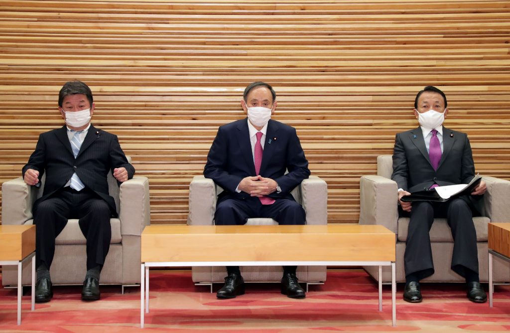 東京で閣僚会議に出席した日本の菅義偉首相（中）、茂木敏充外相（左）、麻生太郎財務相（右）。2021年1月22日。当局は大会を中止せざるを得ないと考えているとの前夜の報道を受け、首相は東京オリンピックの開催を「決意」していると述べた。（資料写真/AFP）
