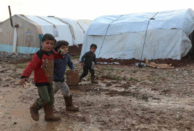 2021年1月20日、シリアのアレッポ地方北部にあるテントの近くでぬかるみを歩く、国内で難民になっているシリアの子供たち。（ロイター/Mahmoud Hassano）