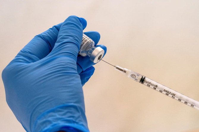 登録薬剤師が、デッドボリューム型注射器に COVID-19 ワクチンを注入する。2021 年 1 月 23 日、米国ニューヨーク市、ブルックリンのウィリアムレイド・アパートメンツ (William Reid Apartments) の即席ワクチン接種会場にて。( ロイター )