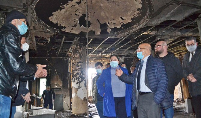 レバノン北部の貧しい港湾都市トリポリで、治安部隊との衝突で反政府デモ隊が夜間に即席爆発物を投げ込んだ翌日の2021年1月29日、リアド・ヤマク同市長(右から3番目)が、セレイル(市の本部)の焼けただれた部屋を視察する。(AFP)