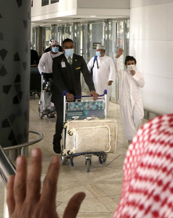 キングハーリド国際空港に到着し、カタールのパスポートを見せる女性。(AFP)