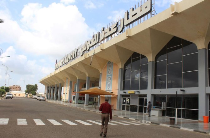 12月30日に爆発が建物を揺らして数十人が死傷した後、2021年1月3日に空港が再開され、イエメンの都市アデンの空港建物に向かって男性が歩いていく。（AFP）