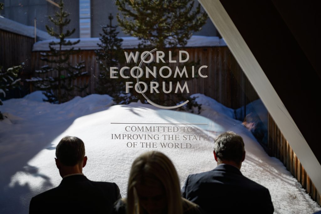 2020年1月23日、ダボスで開催された世界経済フォーラム(WEF)年次総会でメッセージを確認する参加者たち。(AFP通信)