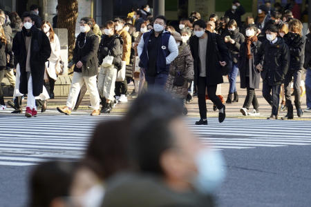 月曜日に東京の渋谷地区の横断歩道に沿ってコロナウイルスの広がりを抑制するために保護マスクを着用した人々。(AP)