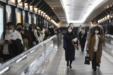 2021年1月22日(金)、東京の夕方、コロナウイルスの蔓延を防ぐためフェイスマスクを着用した人々が駅に向かって歩きます。(AP)
