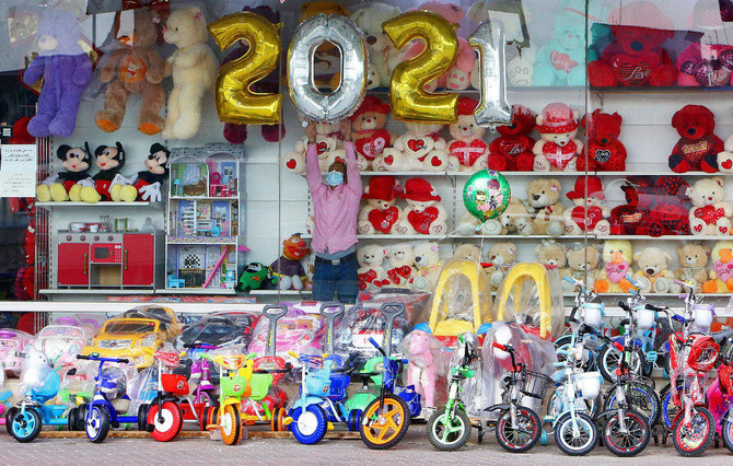 新年を前におもちゃ屋の店頭を飾る店主。クウェート、クウェート市、2020年12月31日（AP）
