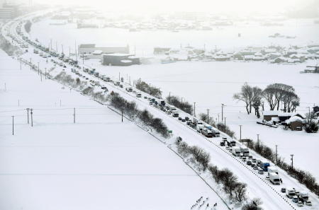 2021年1月10日に撮影された写真では、福井県北陸高速道路の雪の中で車両が立ち往生しています。(Kyodo/via Reuters)